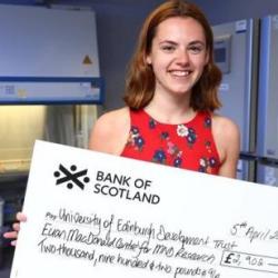 EUSA President Eleri Connick holding a cheque in a lab