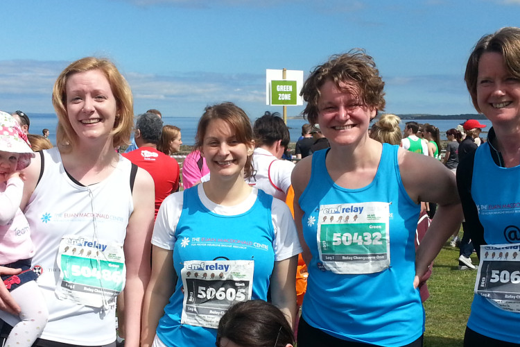 5 people smiling at the camera wearing Euan MacDonald Centre running vests after a race