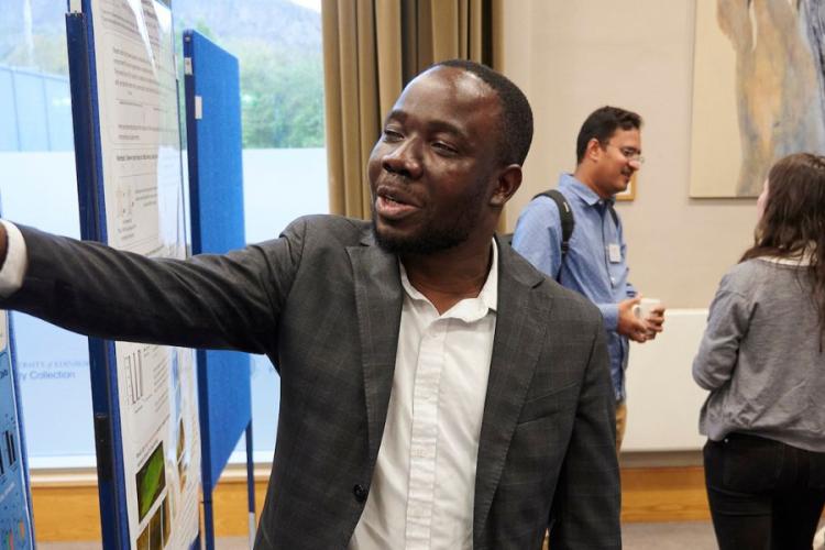 Postdoc researchers showing a poster presentation of their research