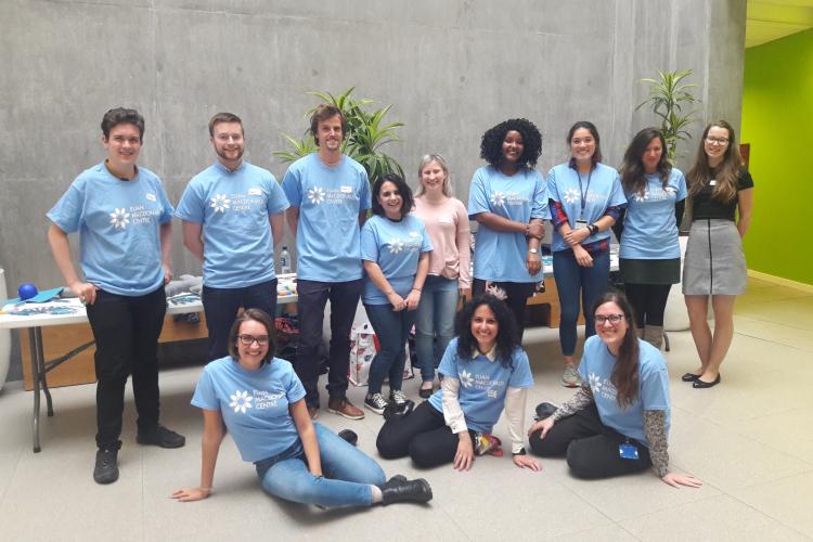 Diverse group of PhD students wearing Euan MacDonald Centre branded t-shirts