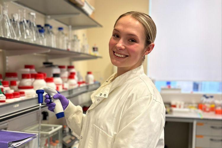 A smiling Alyssa Corbett in the lab