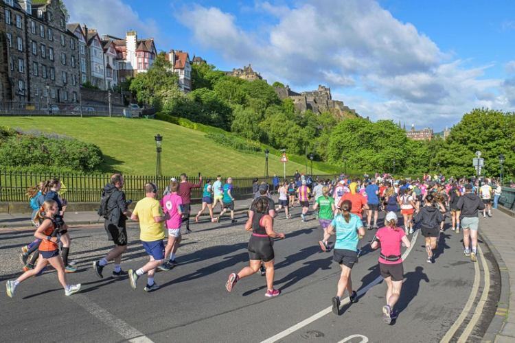 Edinburgh Marathon scenic view of runners running down the Mound in Edinburgh, with Edinburgh Castle in the background