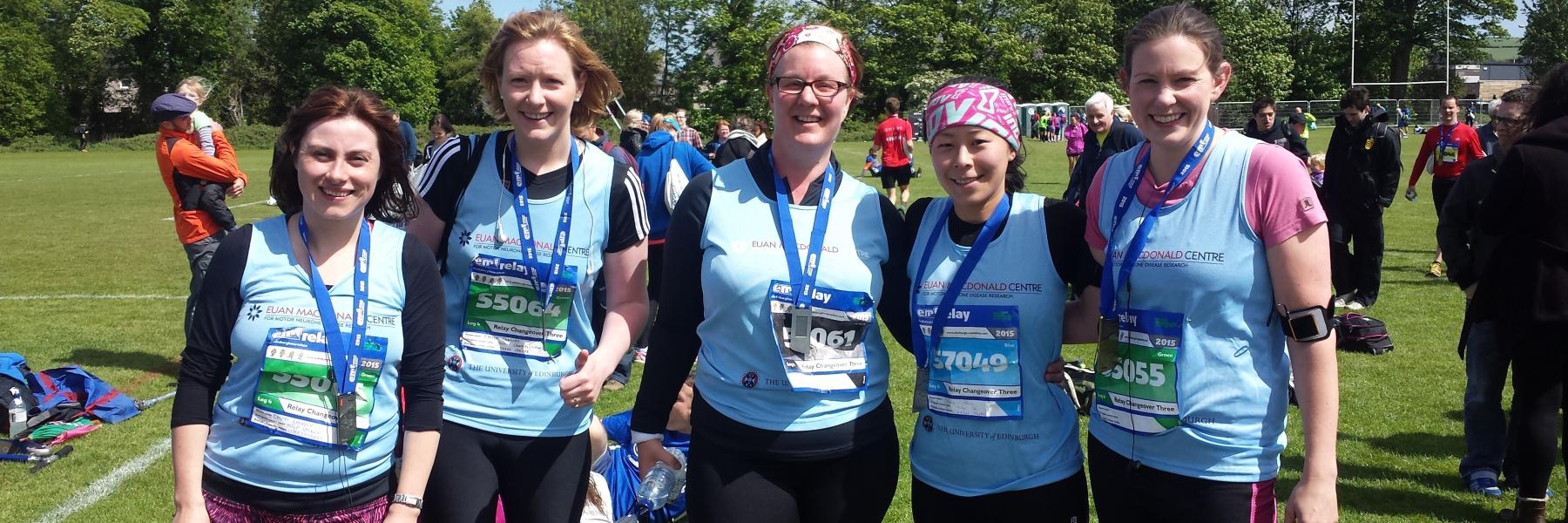 a group of runners wearing medals and Euan MacDonald Centre T-shirts, having just completed the Edinburgh Marathon relay