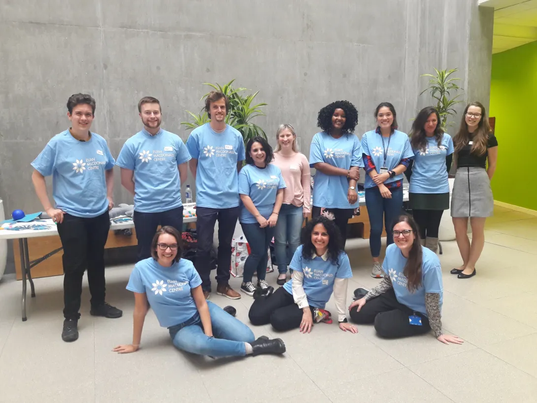 Diverse group of PhD students wearing Euan MacDonald Centre branded t-shirts